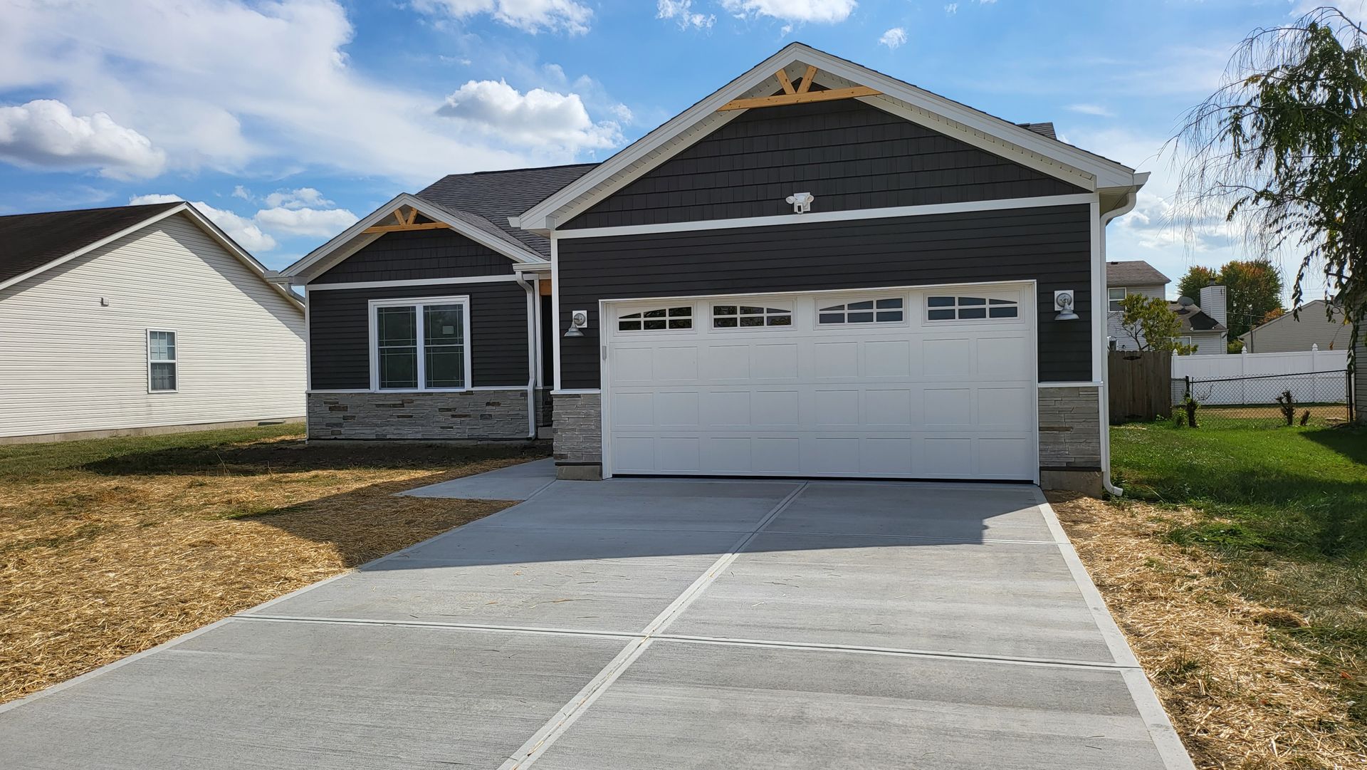 A house with a garage door and a driveway in front of it.