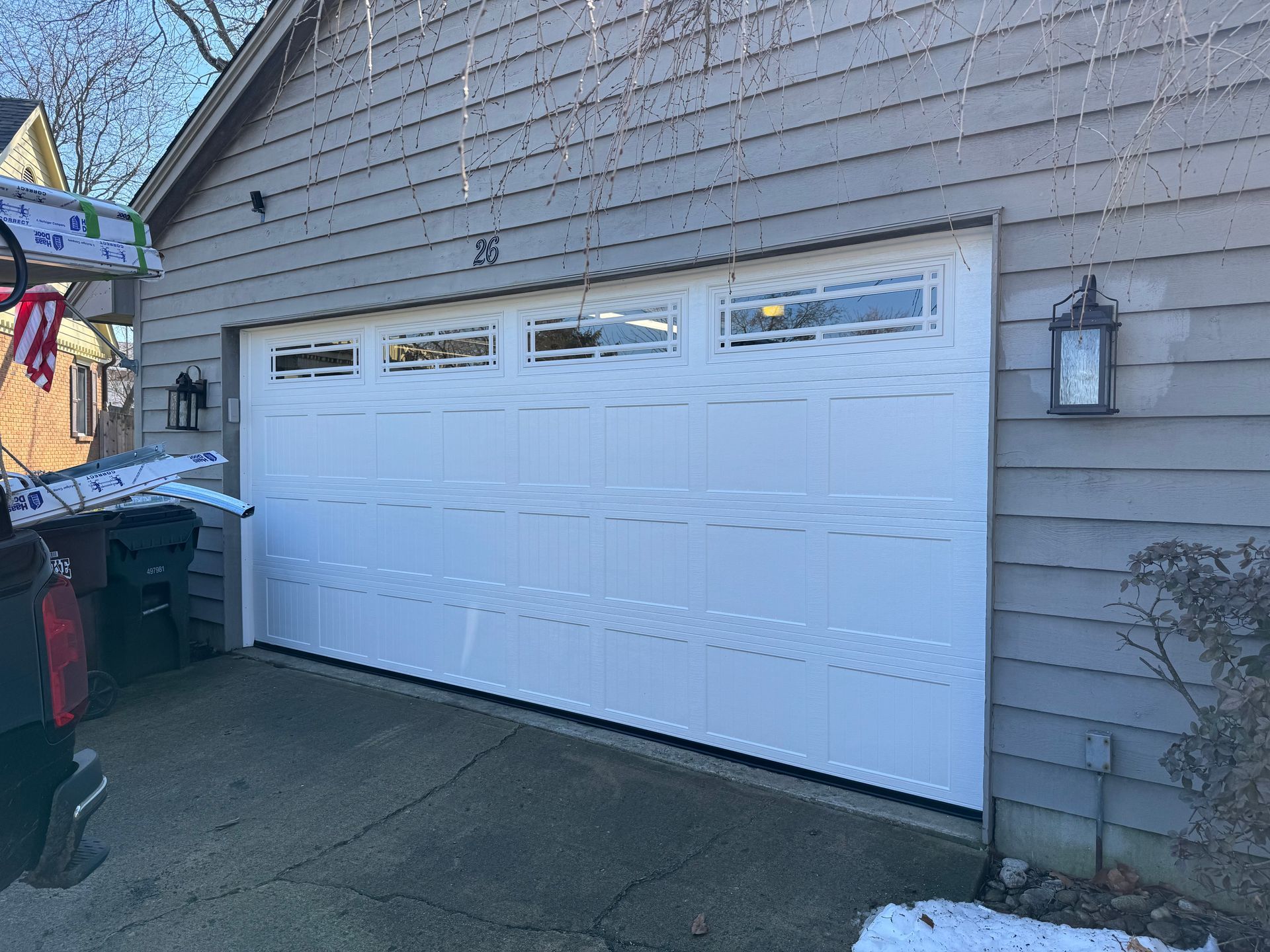 A white garage door is sitting on the side of a house.