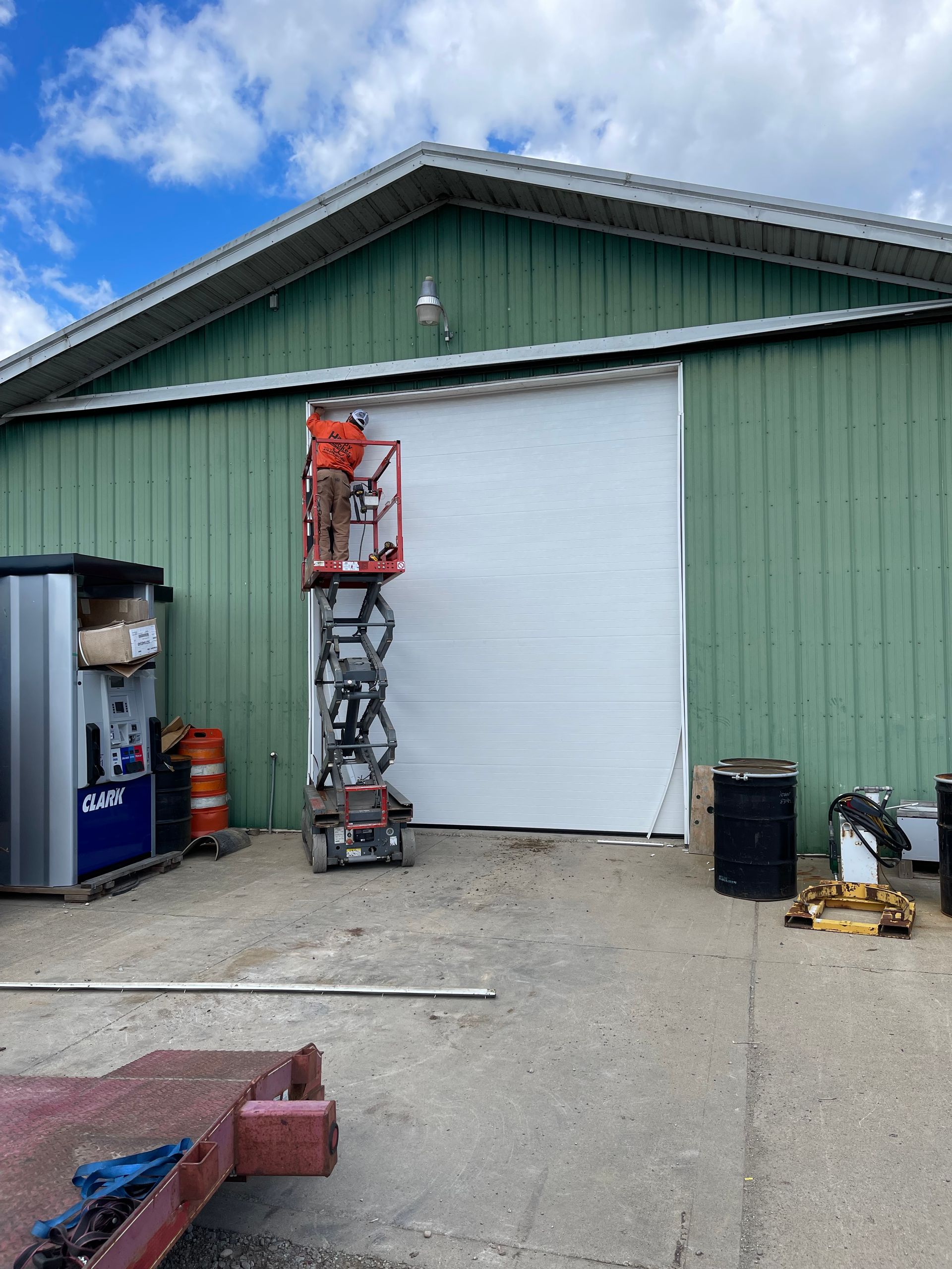 A green building with a white door and a lift in front of it