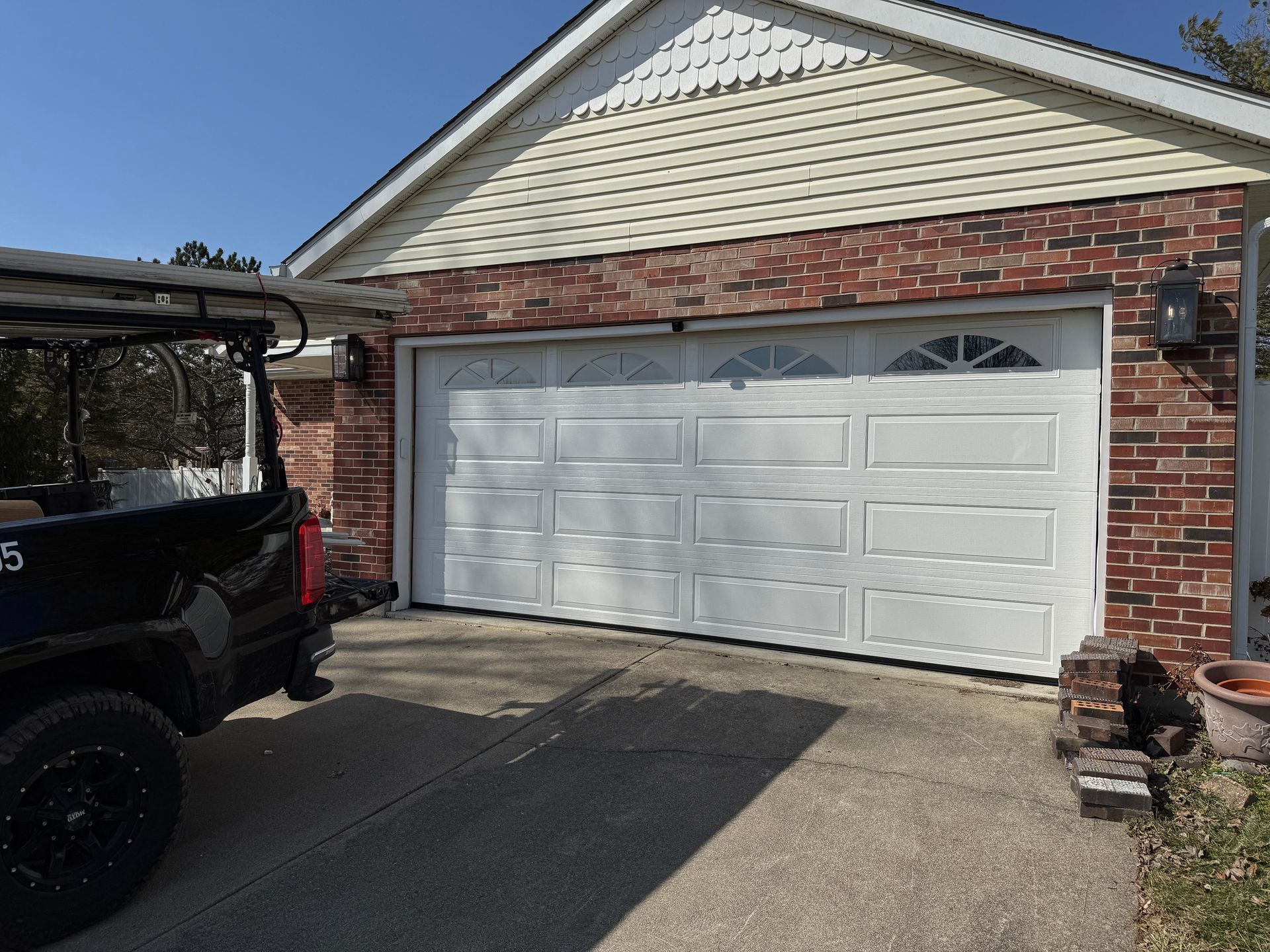 A golf cart is parked in front of a garage door.