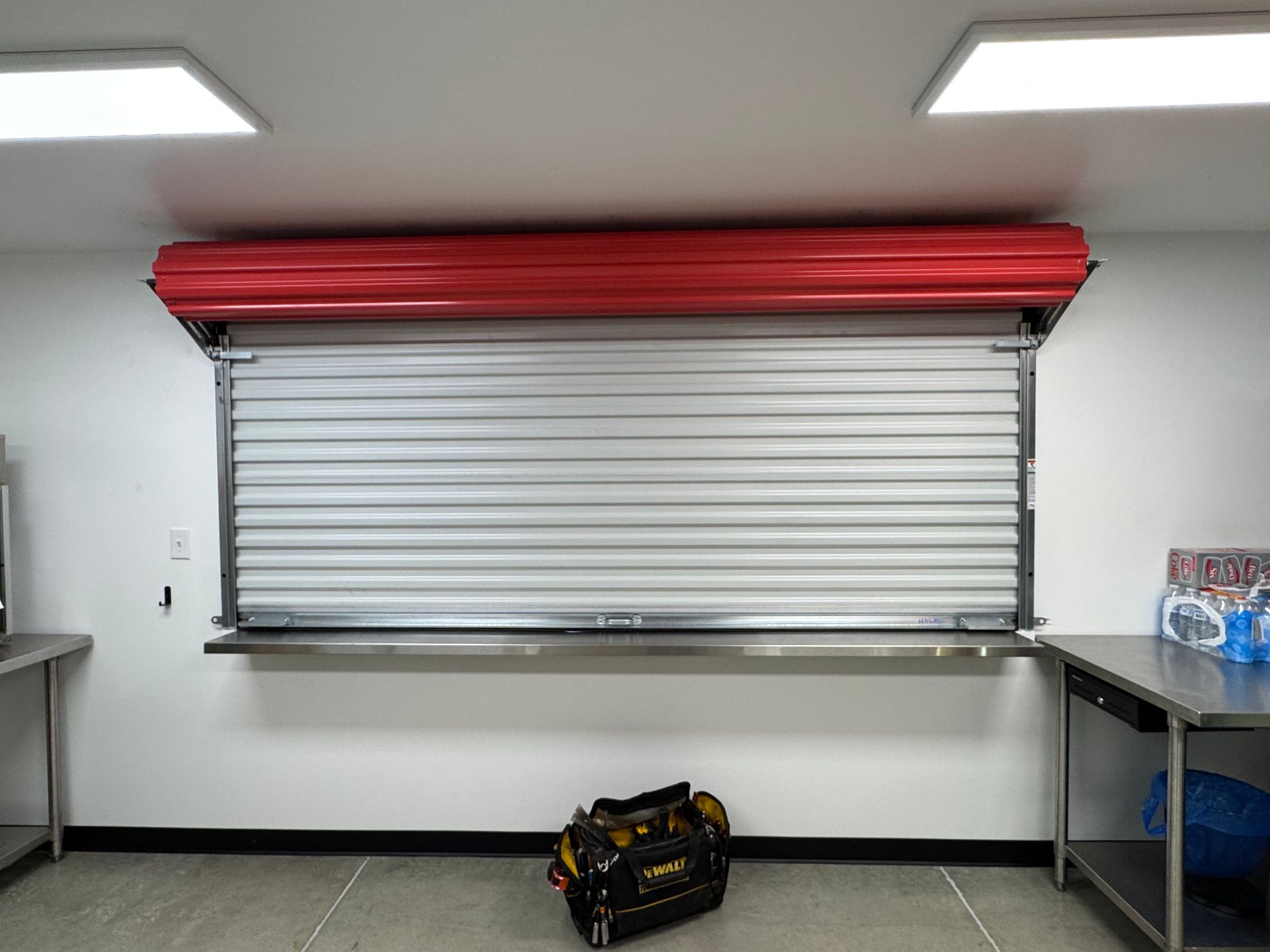 A bag is sitting on the floor in front of a garage door.