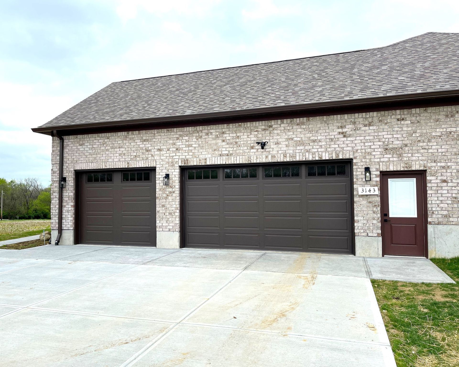 A brick building with three garage doors and a door.