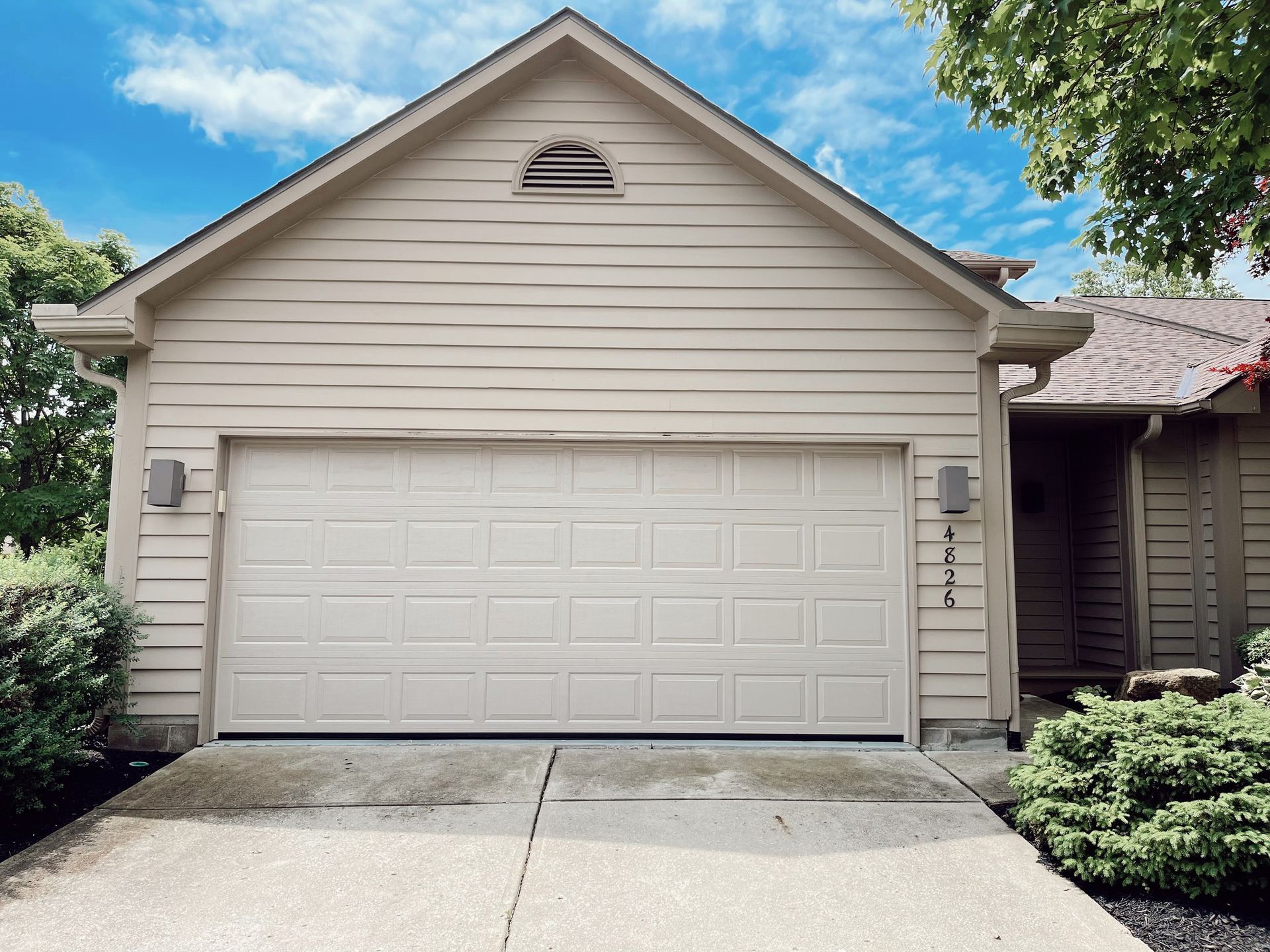 The front of a house with a white garage door