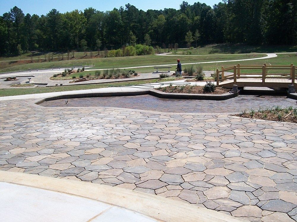 A patio with a bridge in the background and trees in the background