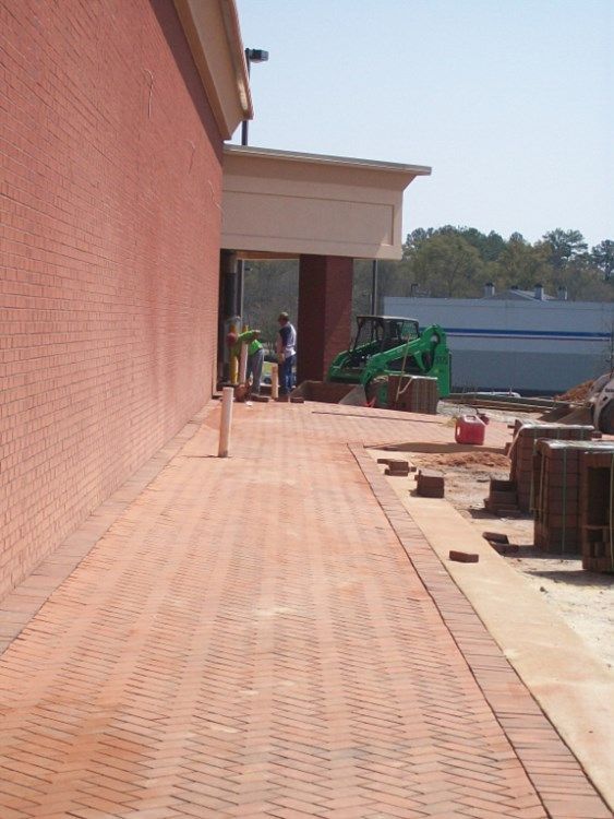 A brick walkway leading to a building under construction