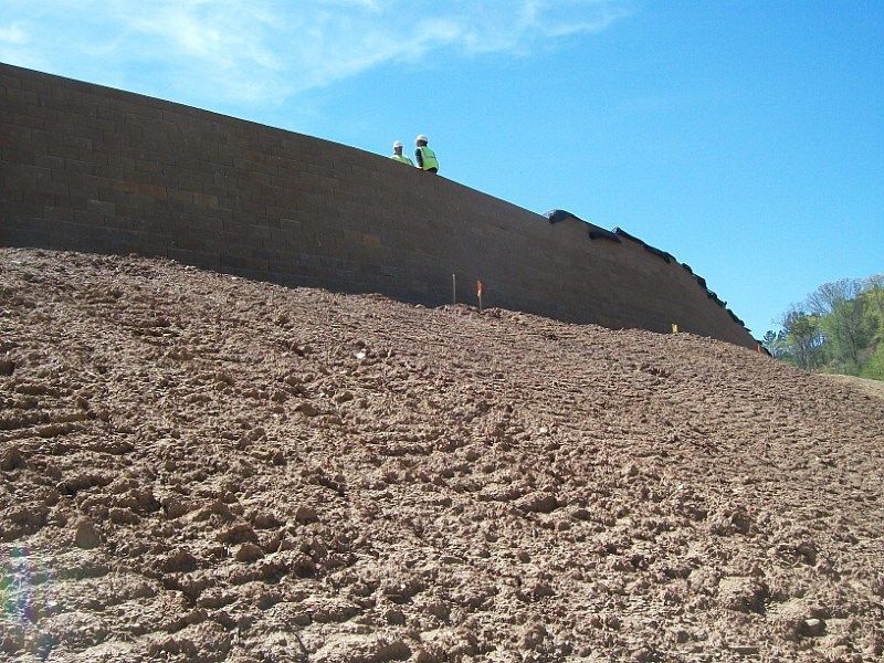 A couple of people standing on top of a dirt hill