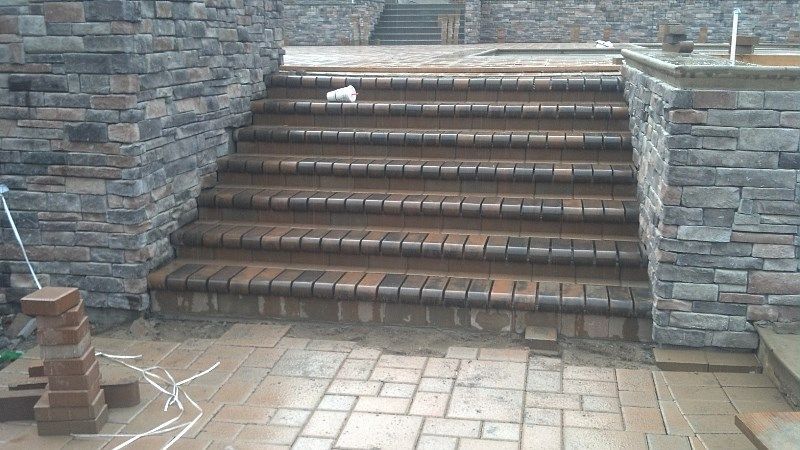 A set of stairs leading up to a stone wall.