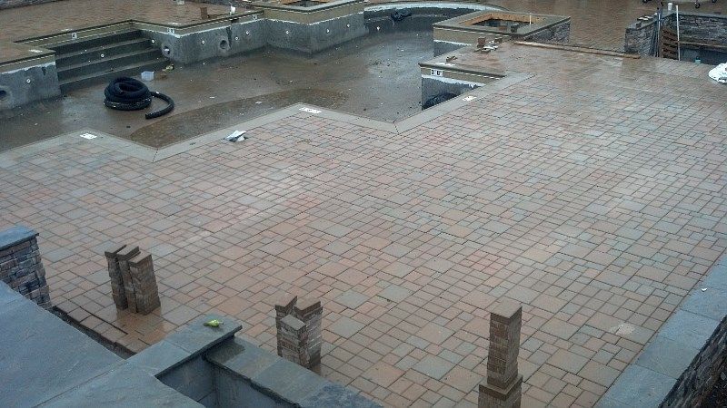 A large swimming pool is being built in a backyard.