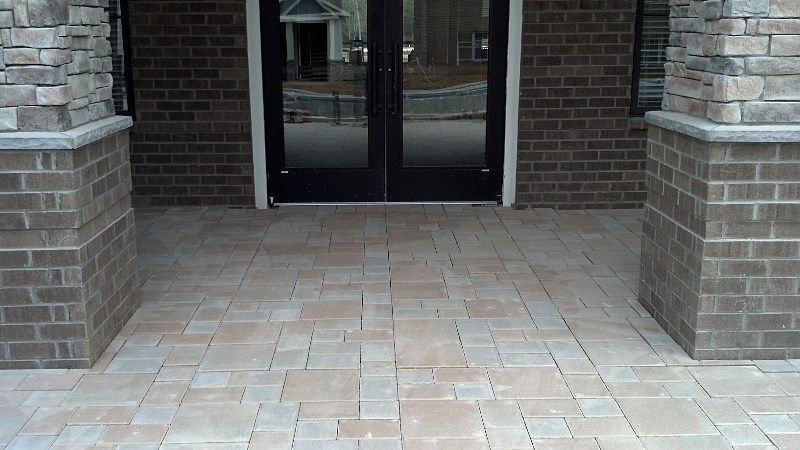 A brick building with a patio in front of it and a door.