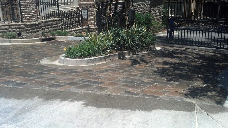 A brick driveway with a fence in the background