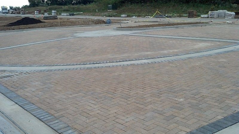 A large brick pavement is being built in a parking lot.