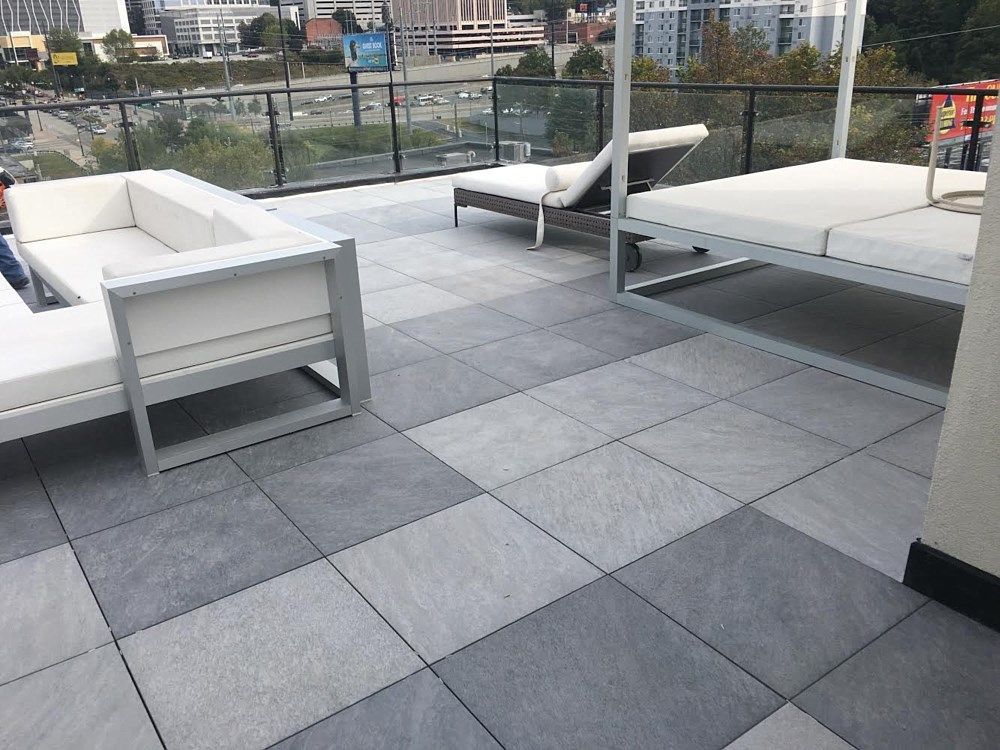 A patio with a couch , chair , and bed on it