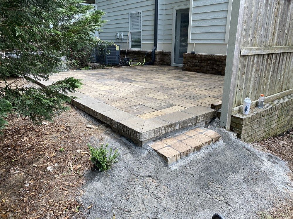 A patio is being built in the backyard of a house.