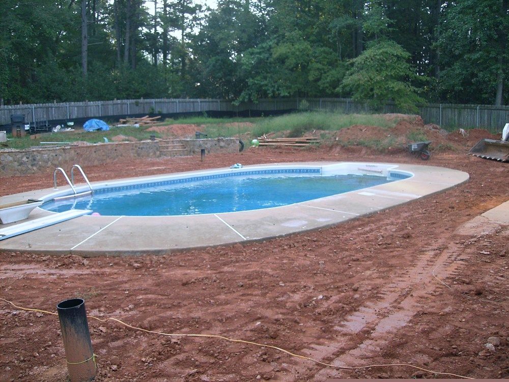 A large swimming pool is being built in a backyard