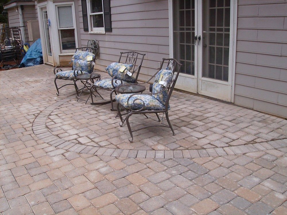 A patio with chairs and tables in front of a house