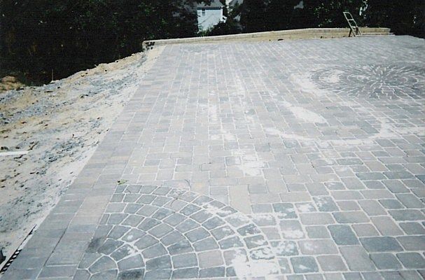 A brick driveway with a circular design on it
