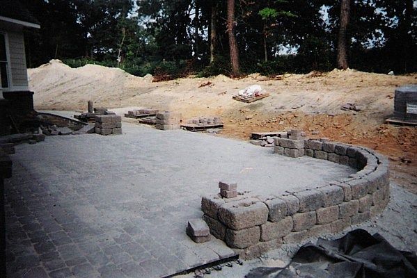 A patio is being built in the backyard of a house