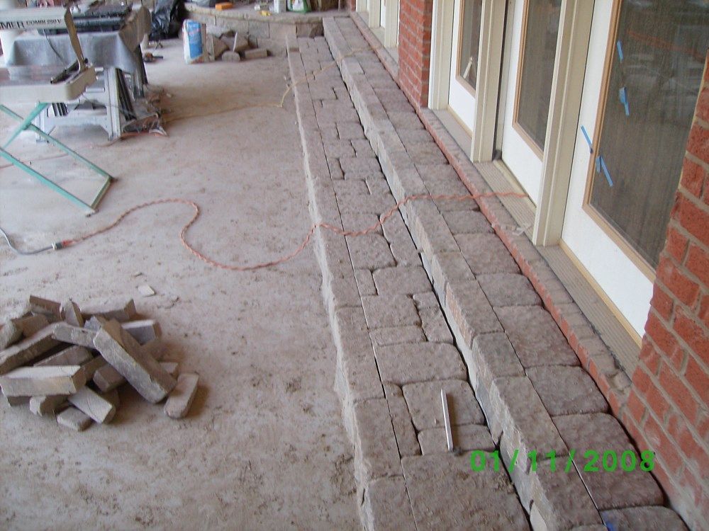A brick walkway is being built in front of a brick building