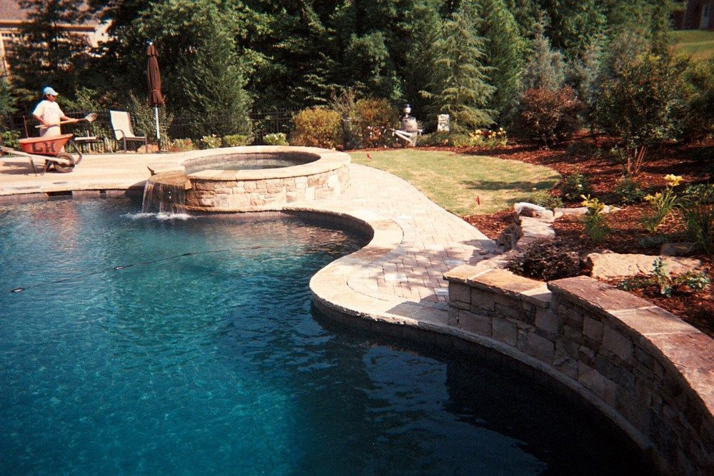 A large swimming pool with a waterfall in the middle