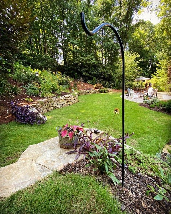 There is a bird feeder in the middle of the garden.
