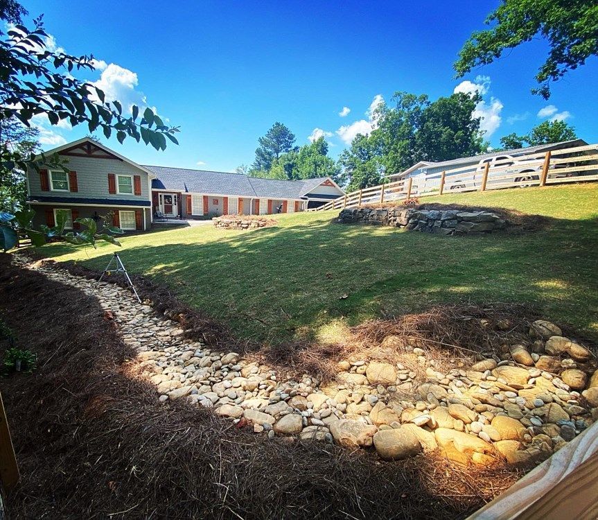 A house sits on a hill with a fence around it