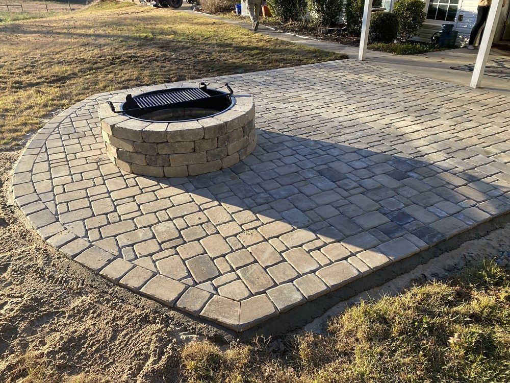 A fire pit is sitting on top of a brick patio.