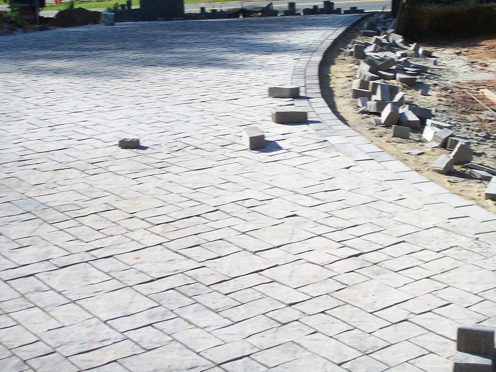 A brick walkway is being built on a sunny day