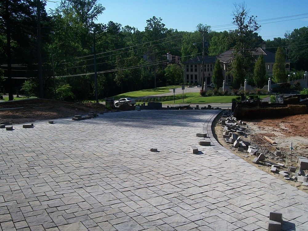 A brick driveway is being built in front of a house