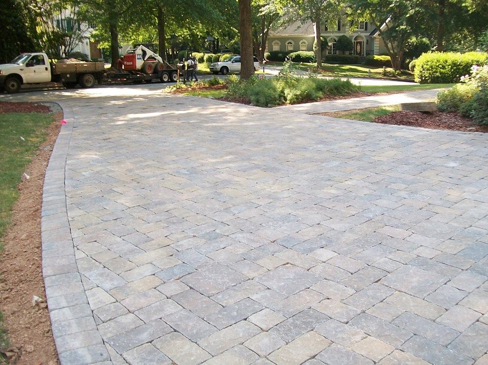 A brick driveway with a truck in the background