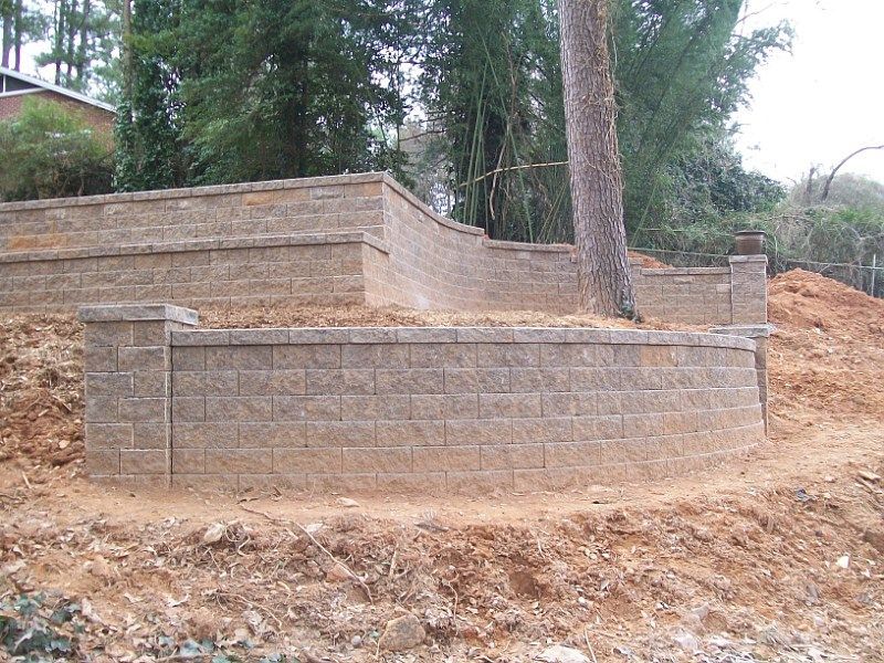 A brick wall is sitting on top of a dirt hill