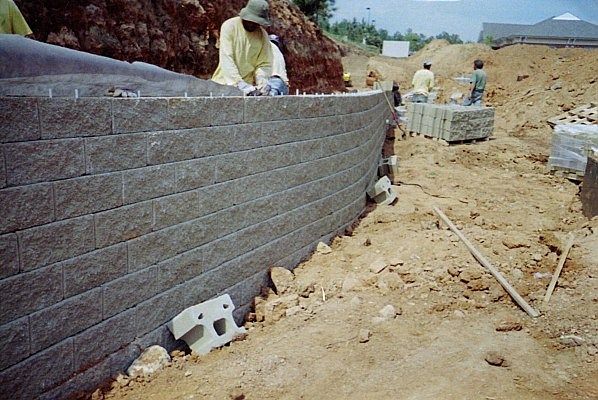 A group of men are working on a brick wall