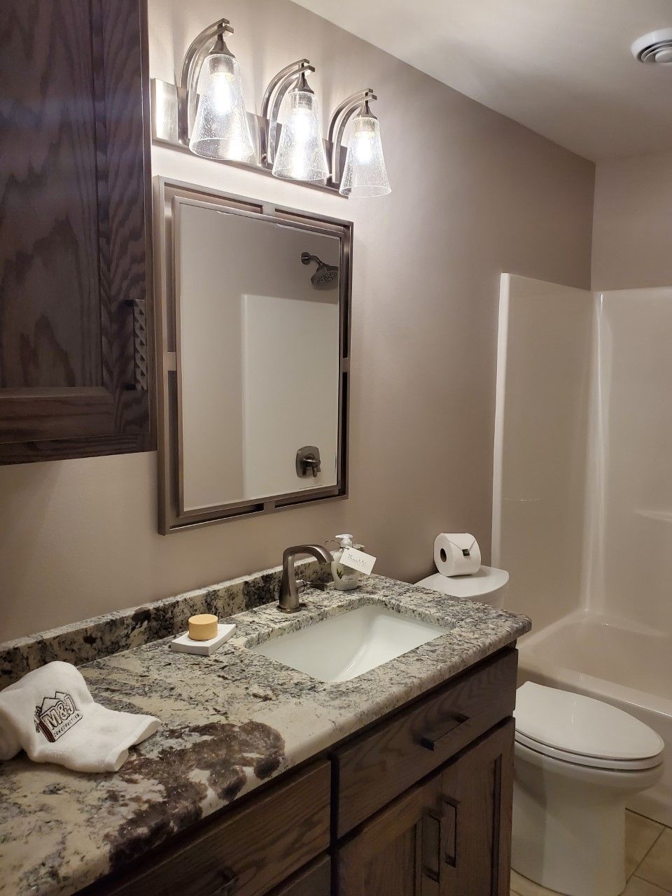 A bathroom with a sink, toilet, and mirror