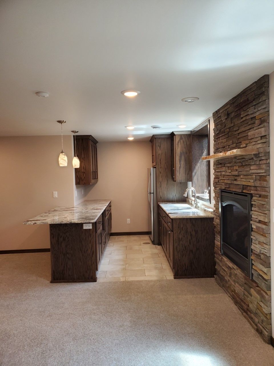 A kitchen with granite countertops, stainless steel appliances, and a fireplace