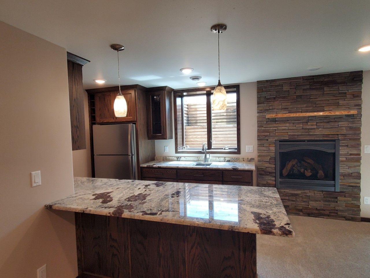 A kitchen with a granite counter top and a fireplace
