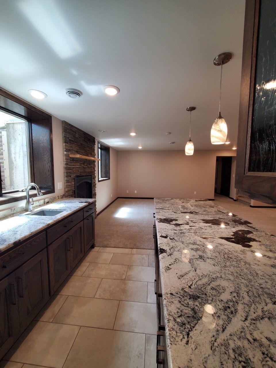 A kitchen with granite counter tops, cabinets, and a fireplace