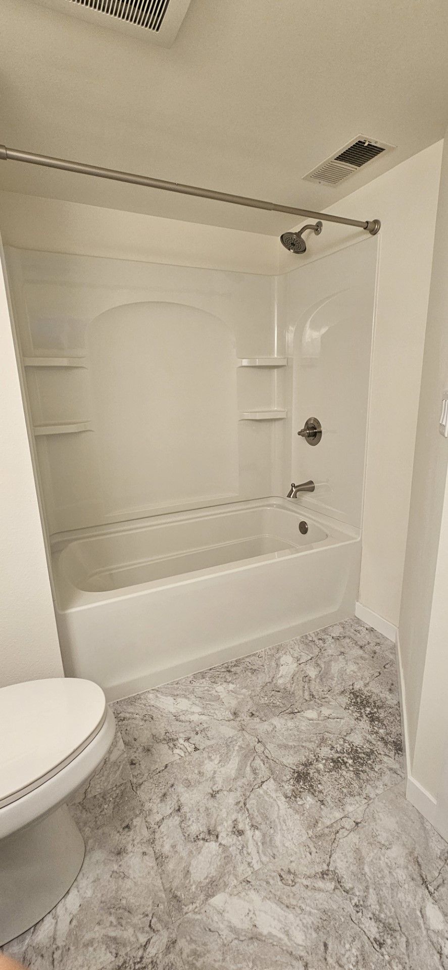 A bathroom with a toilet, bathtub and shower