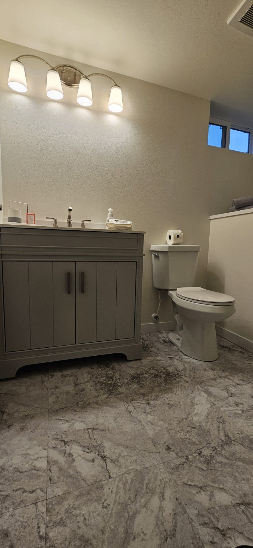 A bathroom with a sink, toilet, and vanity
