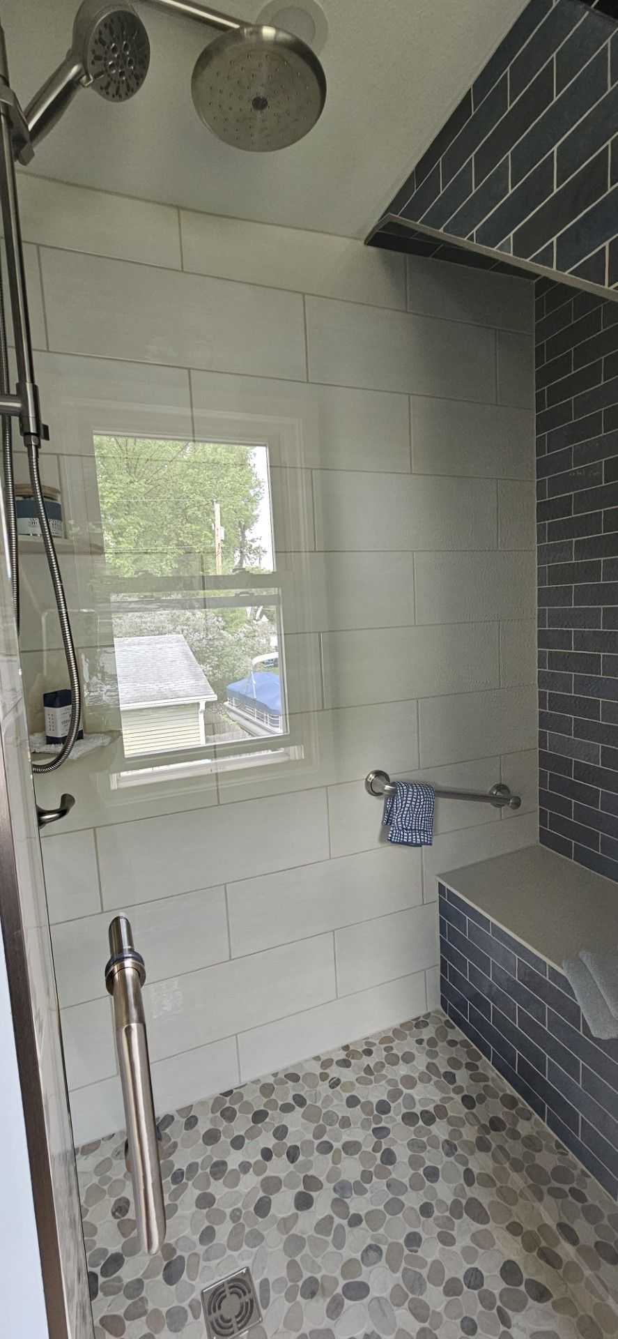 A bathroom with a walk in shower and a window