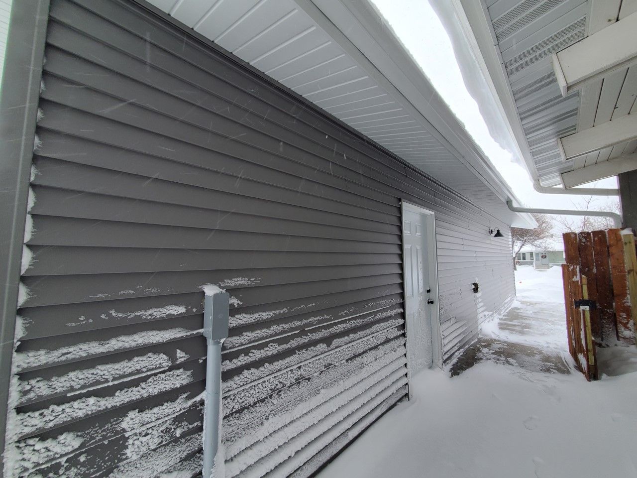 A house with a lot of snow on the side of it