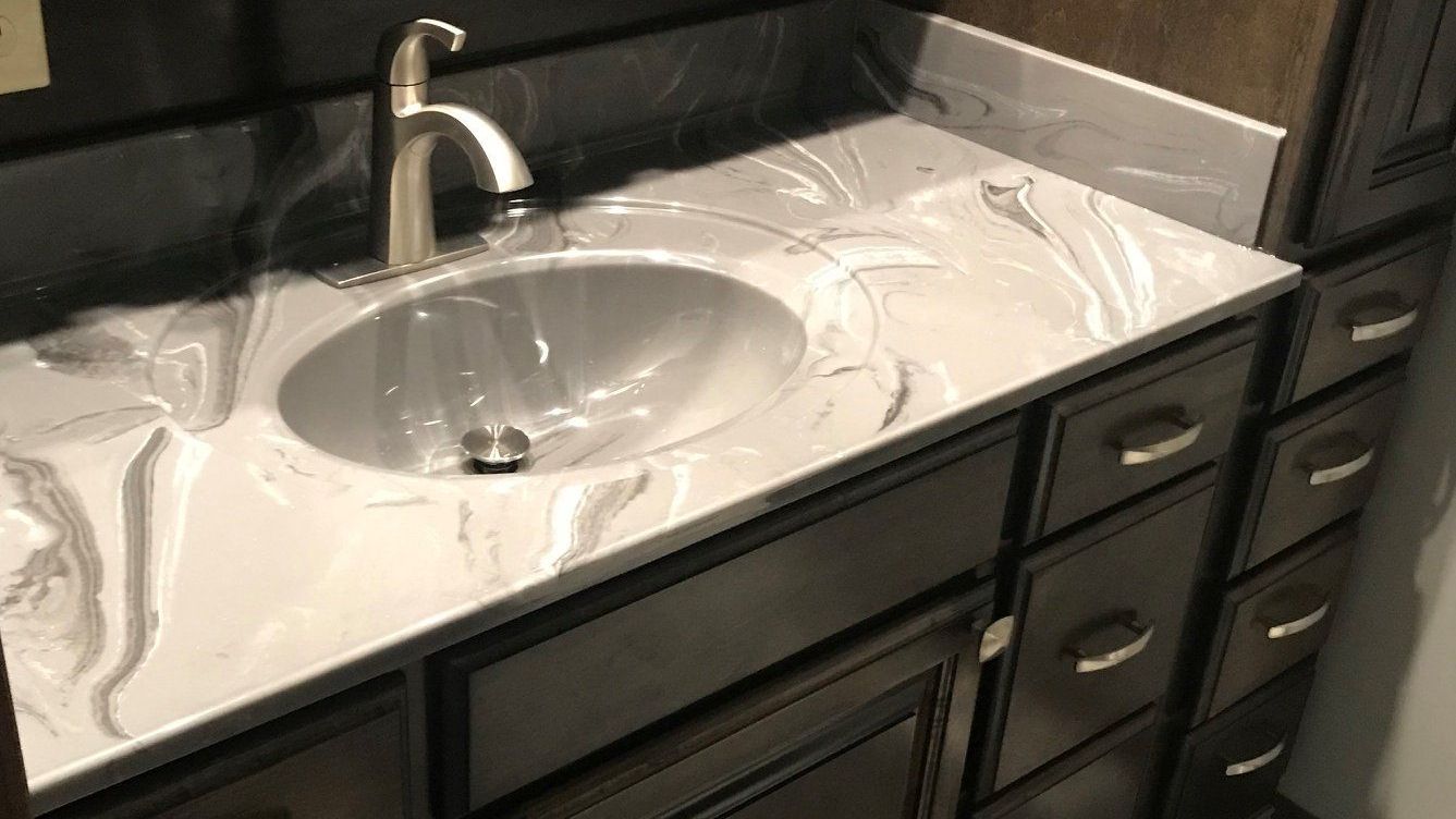 A bathroom vanity with a sink, faucet and drawers.