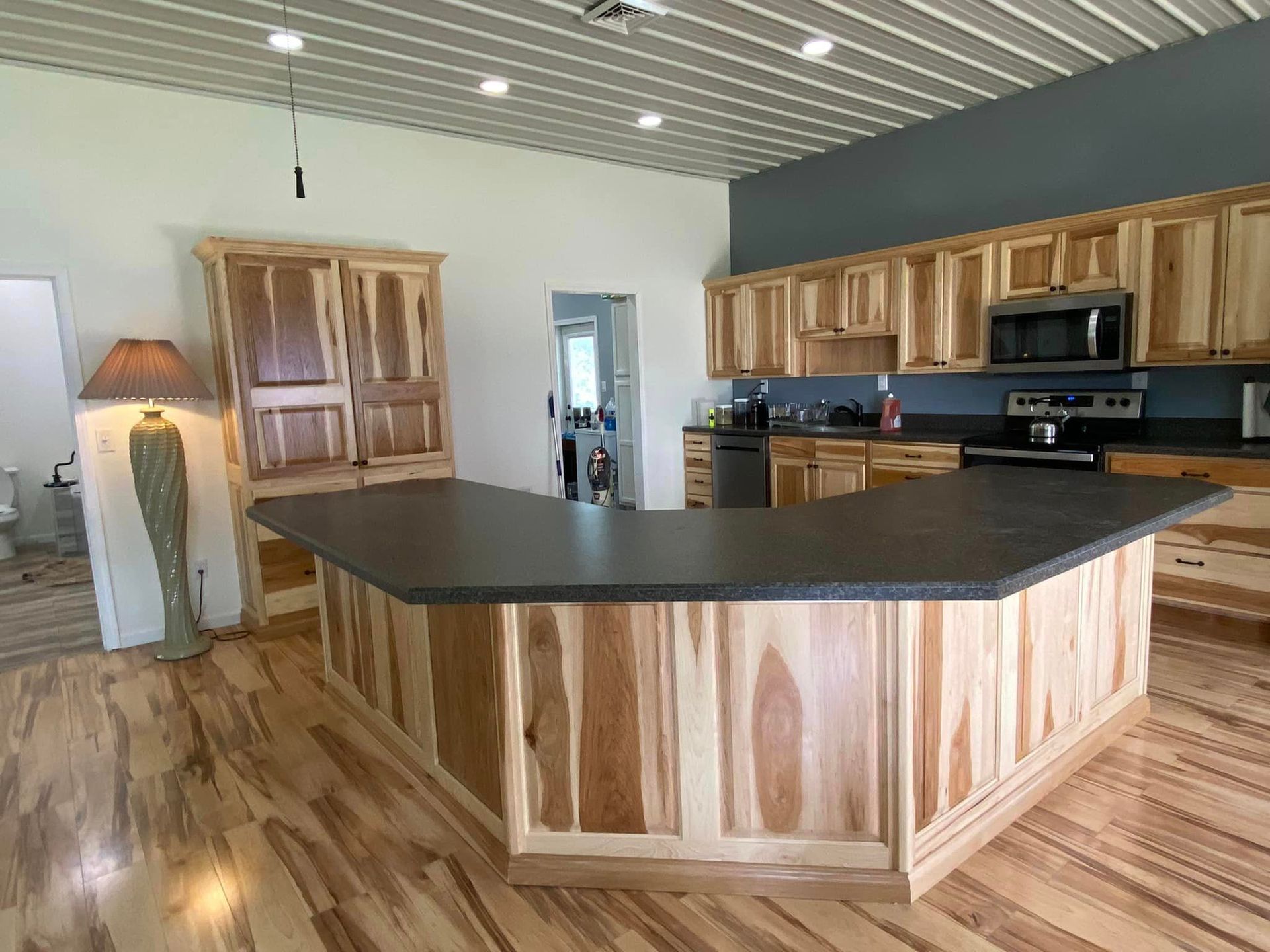 A kitchen with wooden cabinets and a large island.
