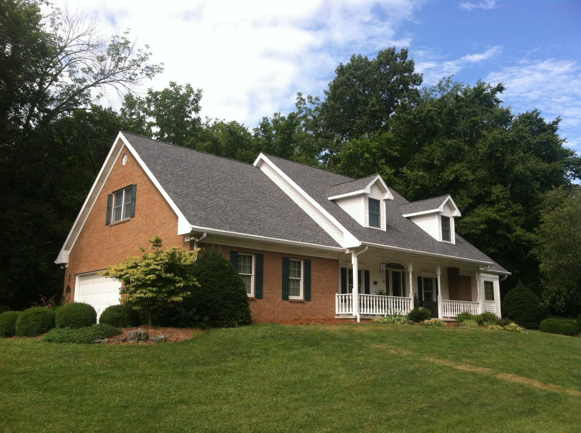 A large brick house with a gray roof and white trim