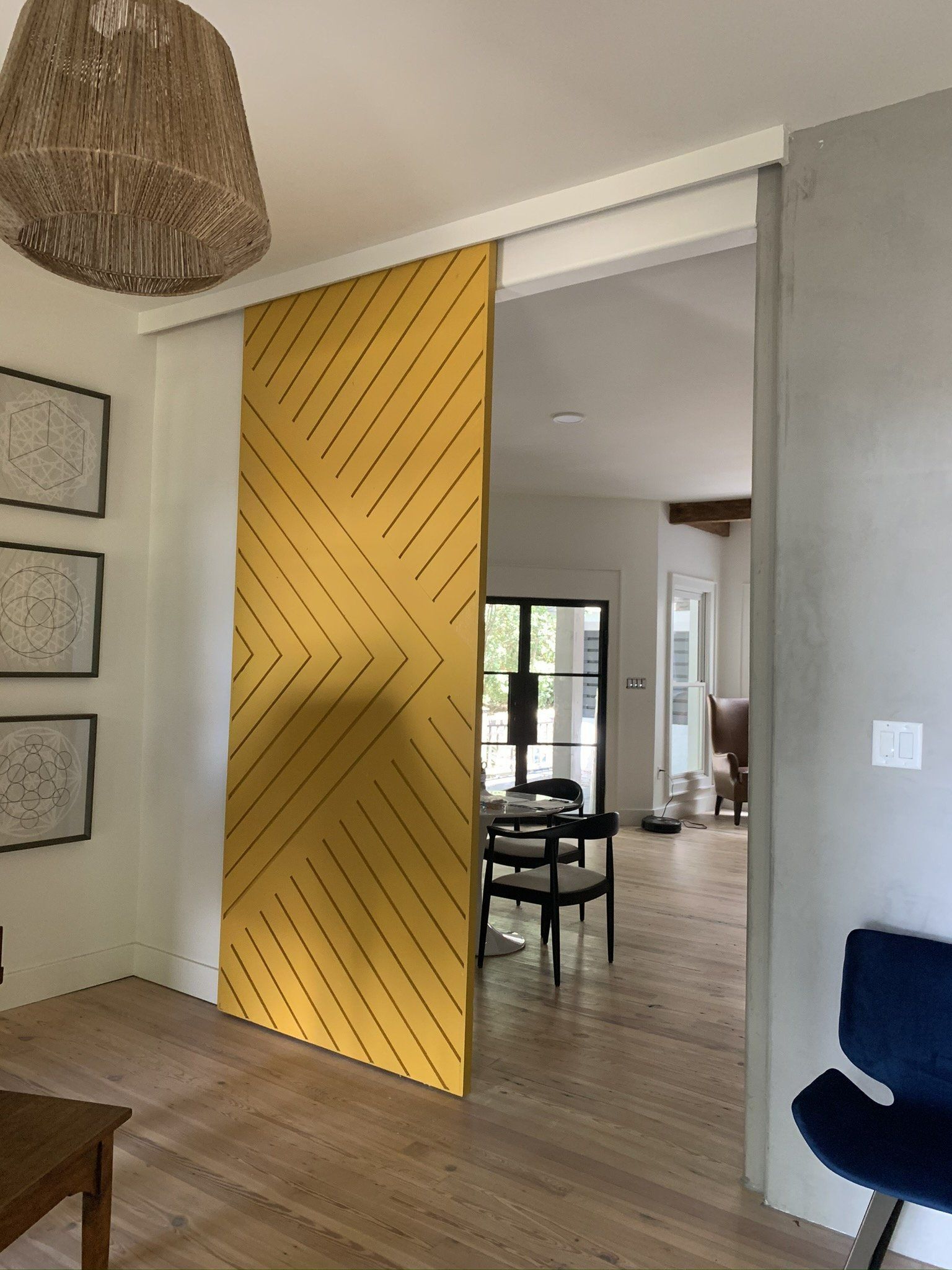 A yellow sliding door between a living room and dining room.