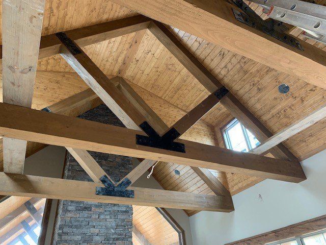 the ceiling of a house with wooden beams and a brick chimney