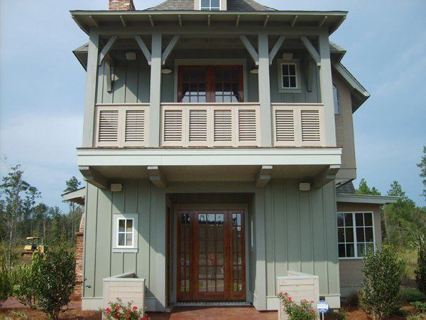 the front of a house with a balcony and shutters