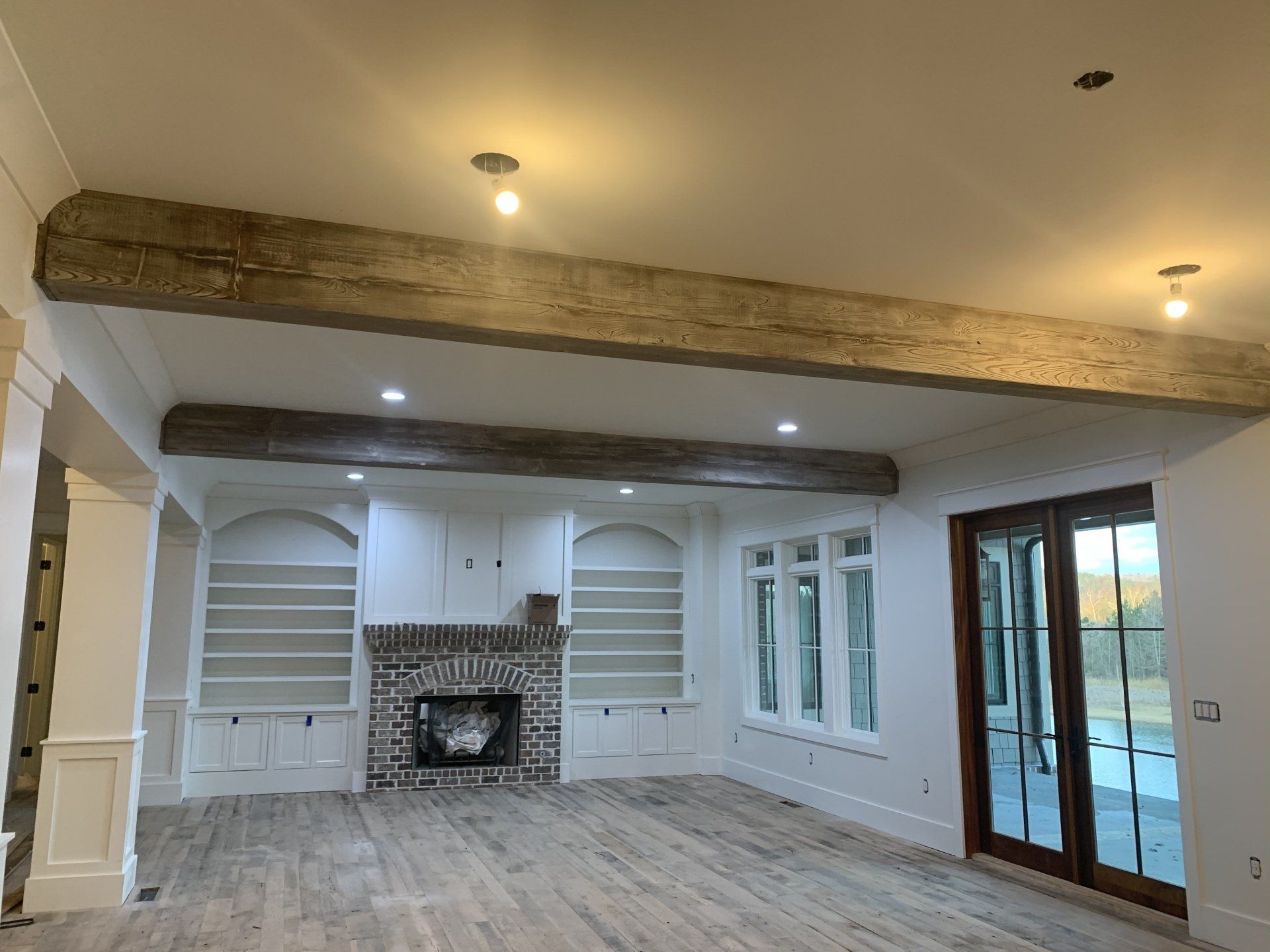 a living room with a fireplace, shelves, and sliding glass doors