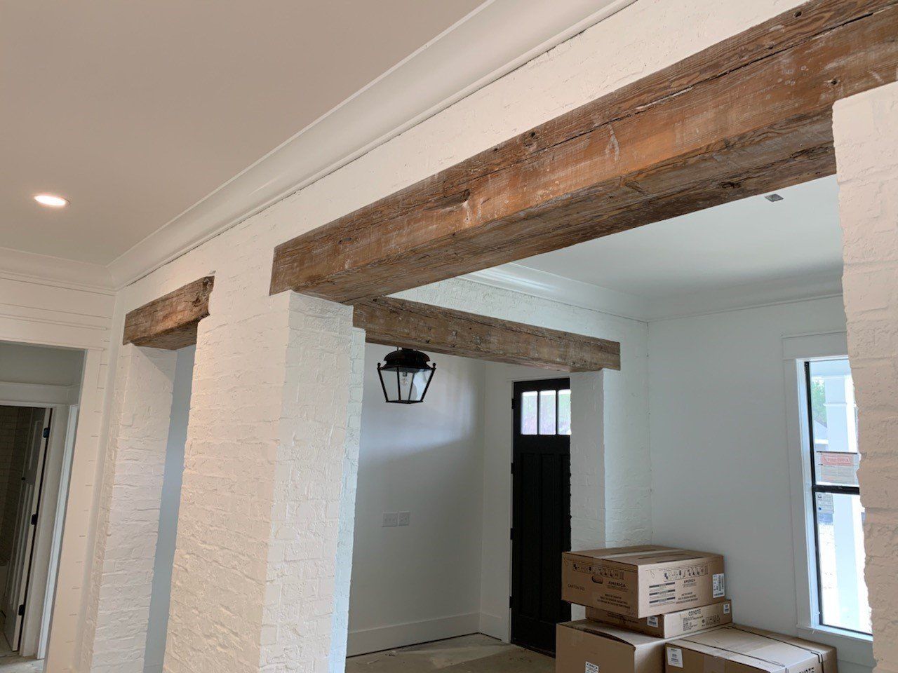 a hallway with wooden beams and boxes stacked on the floor