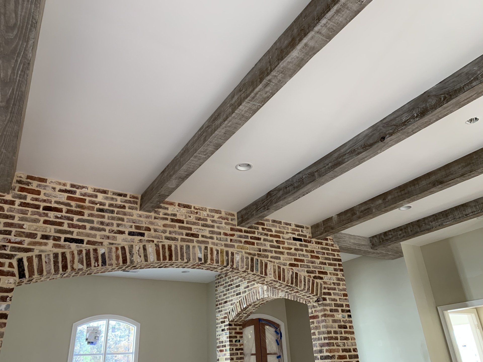 a room with a brick wall and wooden beams on the ceiling
