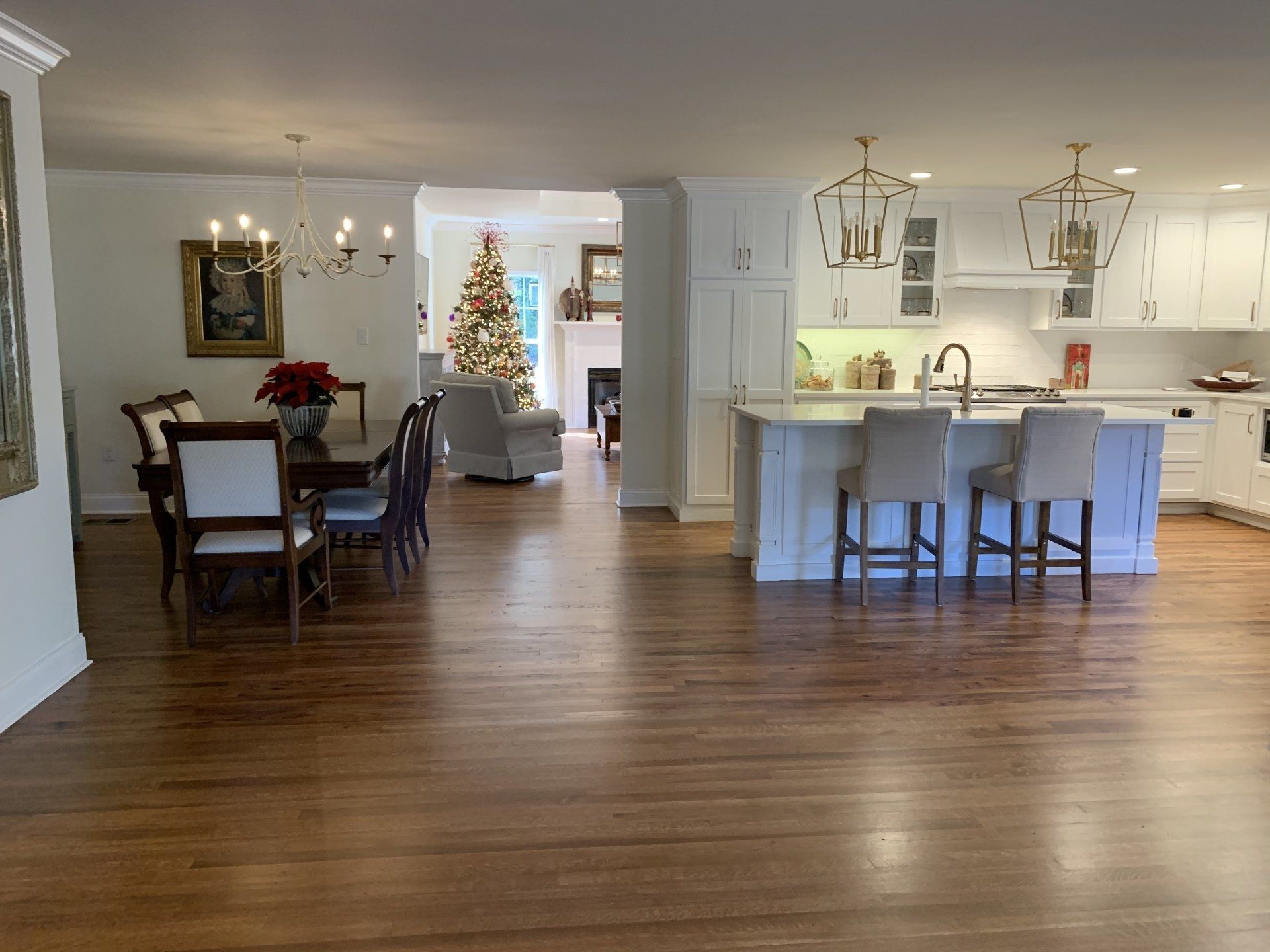 a kitchen and dining room in a house with a Christmas tree in the background