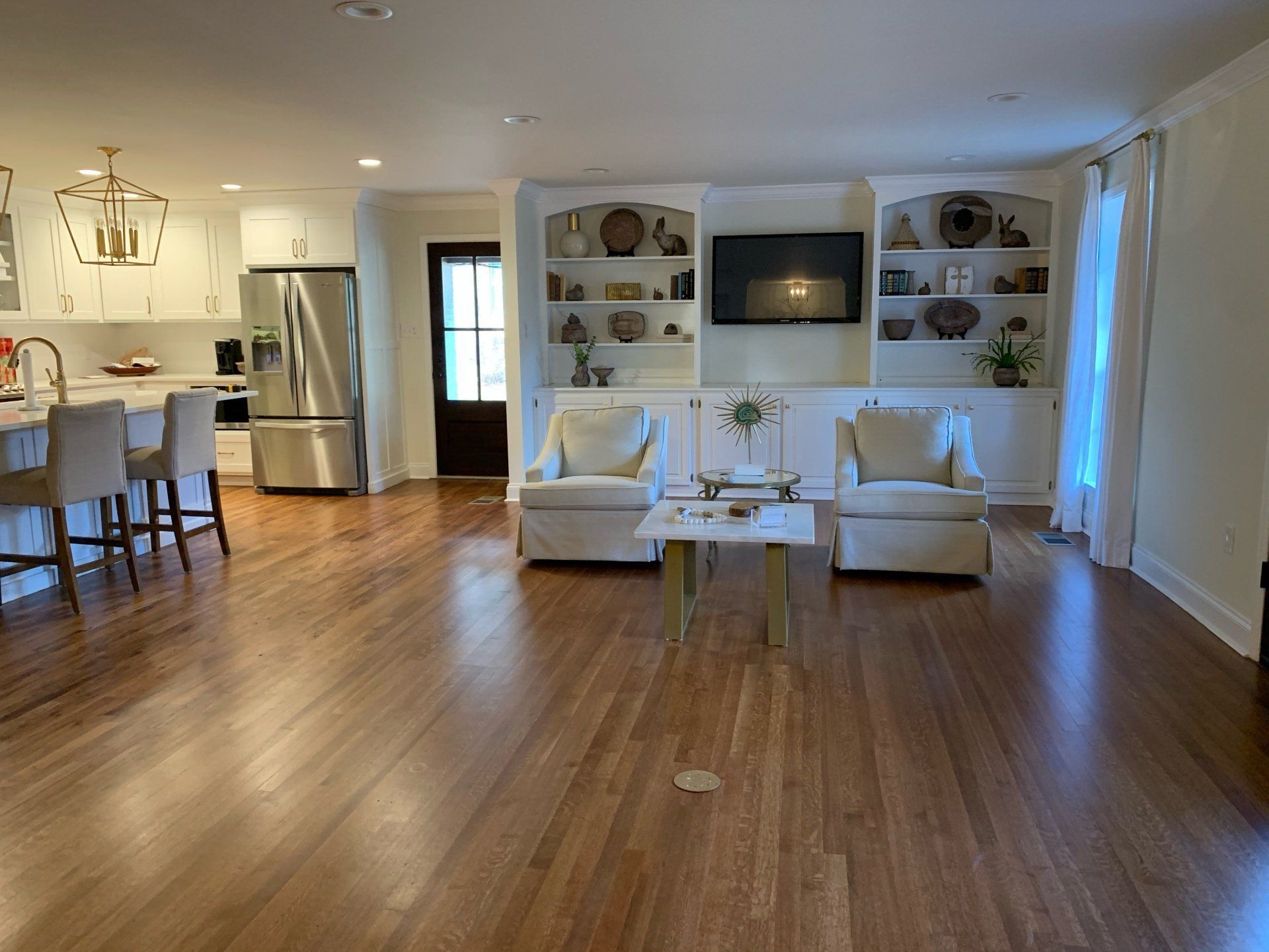 a living room with hardwood floors and a flat screen tv